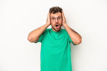 Young caucasian man isolated on white background being shocked, she has remembered important meeting.