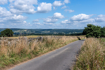 road in the countryside with blue skies and clouds, countryside scene in UK