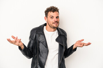 Young caucasian man isolated on white background doubting and shrugging shoulders in questioning...