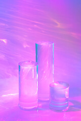 Abstract surreal scene - empty stage with three clear glass cylinder podiums on pastel neon pink holographic background in water. Pedestal for cosmetic product packaging mockups display presentation