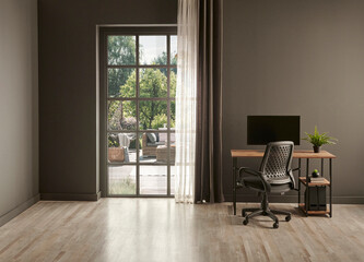 Grey living room office, monitor, chair vase of green plant in front of the window garden view.