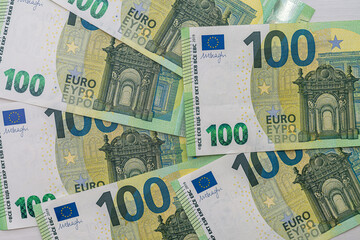 beautiful new 100 euro banknotes laid out on a spacious table