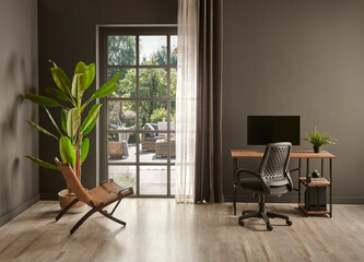 Grey living room office, monitor, chair vase of green plant in front of the window garden view.