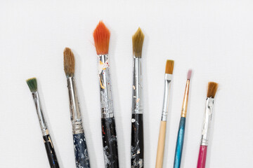Variety of artist brushes on white canvas background
