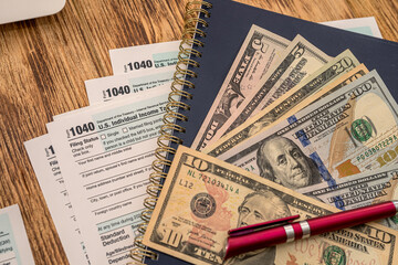 the new US 1040 tax forms feature dollar bills and a red pen