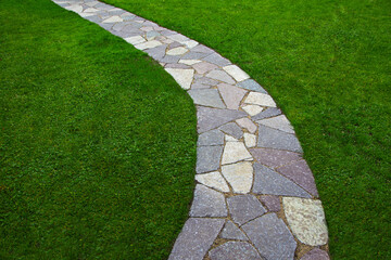 garden path lined with natural stone of gray and pink color