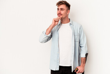 Young caucasian man holding crutch isolated on white background looking sideways with doubtful and skeptical expression.