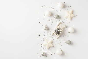 Top view photo of white and silver christmas tree decorations small sleigh with silver star balls stars and sequins on isolated white background with copyspace