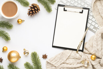 Top view photo of clipboard with paper sheet pen keyboard cup of hot drinking gold christmas tree balls pine twigs cone anise and knitted scarf on isolated white background with blank space