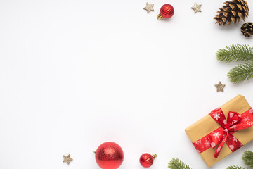 Top view photo of pine twigs red christmas tree balls cones stars and gift box with red bow on isolated white background with copyspace