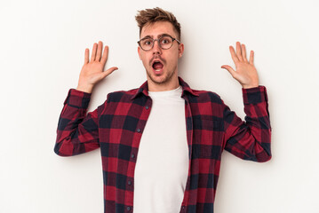 Young caucasian man isolated on white background being shocked due to an imminent danger