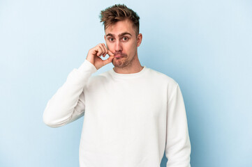 Young caucasian man isolated on blue background with fingers on lips keeping a secret.