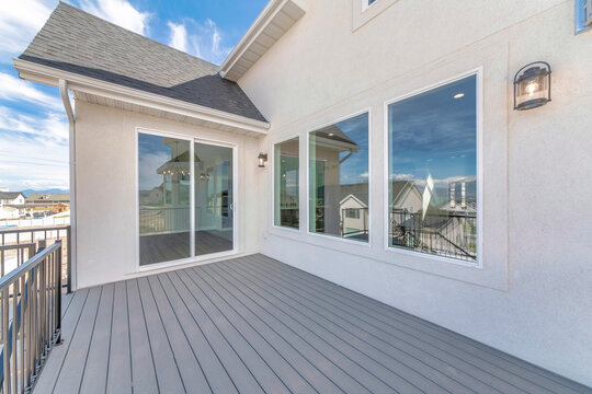 Deck Of A House With Reflective Sliding Glass Door And Picture Windows