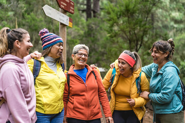 Fototapeta Group of women with different ages and ethnicities having fun walking in the woods - Adventure and travel people concept obraz