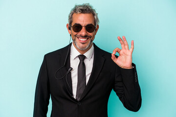 Middle age bodyguard caucasian man isolated on blue background  cheerful and confident showing ok gesture.