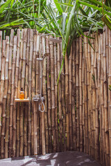 Outdoor shower with bamboo wall and palm tree. Bathroom in tropical hotel. Vacations in Africa....