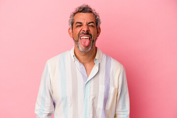 Middle age caucasian man isolated on pink background  funny and friendly sticking out tongue.