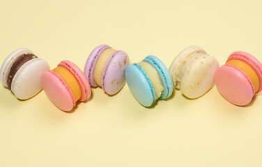 baked round macarons on a beige background, delicious dessert, top view