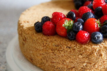 Cake decorated with fresh berries.  Honey cake.