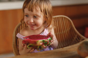 Cute little girl eat pitahaya tropical fruit