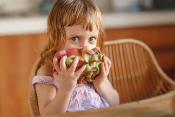 Cute little girl eat pitahaya tropical fruit