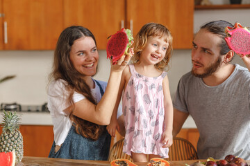 Happy caucasian family of mother, father and little girl daughter have fun on the kitchen. Glad...