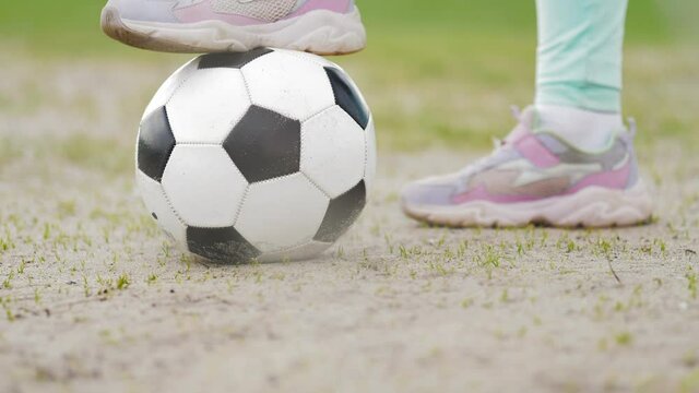 Foot on soccer ball. Feet athletes-women with a soccer ball.