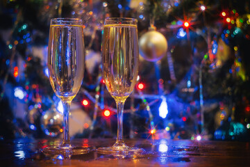 two glasses of champagne on the background of a Christmas tree with lights