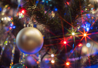 christmas ball and on a spruce branch close-up and lights