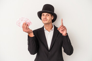 Young magician caucasian man holding a magic cards isolated on white background