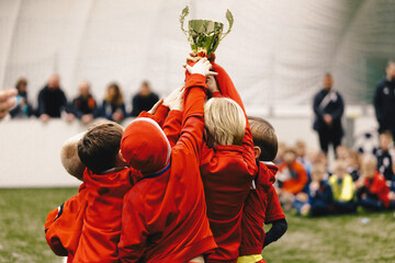 Cheerful Children Celebrating Success in Football Tournament Game. Junior Sports Team Rising Golden...