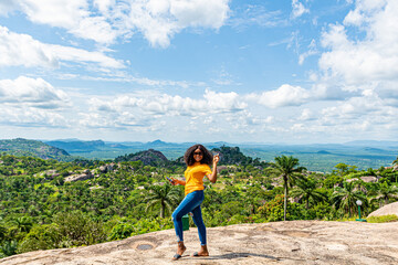 portrait of a black girl smiling and posing against a beautiful landscape