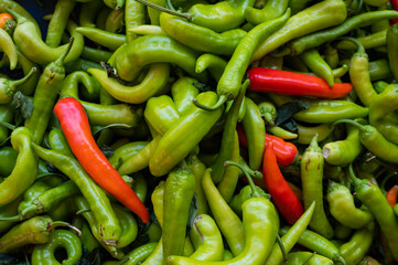 Close-up on a shelf with green and red peppers in the market.