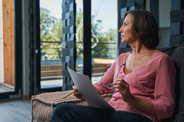 Elderly female getting distracted from reading document