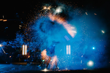 Fire show, dancing with flame, male master juggling with fireworks, performance outdoors, draws a...