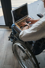 Person with disability using laptop from wheelchair