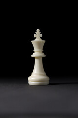 isolated white king chess piece on black background.