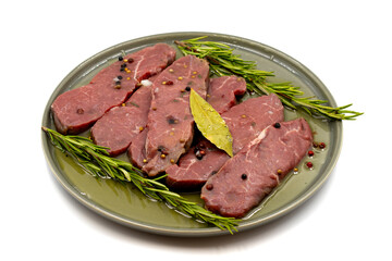 Marinated beef tenderloin on a white background. Beef fillet marinated with olive oil and various spices