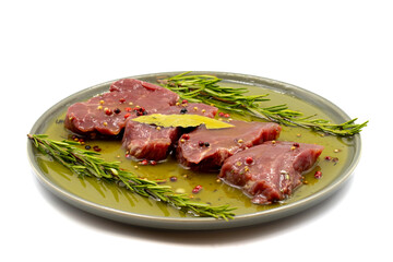Marinated beef tenderloin on a white background. Beef tenderloin marinated with olive oil and various spices