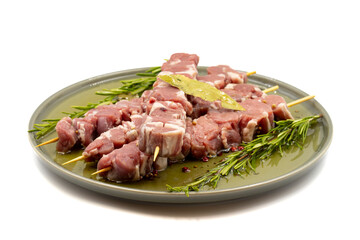 Fototapeta premium Marinated raw lamb skewers on a white background. Lamb skewers marinated in olive oil and various spices