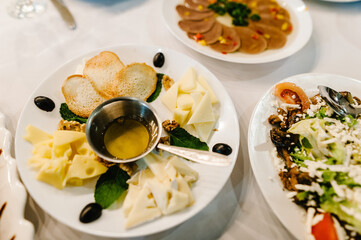 The holiday table with appetizer cheese, meat snacks. Served table with food. Festive table. Wedding table, food.