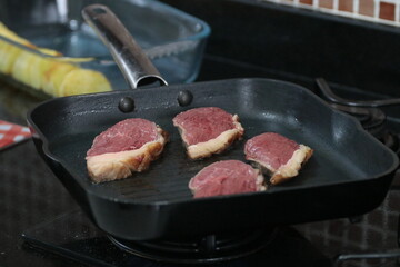 Peça de carne picanha inteira e com cortes crua e grelhada em frigideira