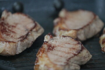 Peça de carne picanha inteira e com cortes crua e grelhada em frigideira