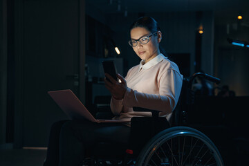 Elegant woman with disability holding gadgets indoors