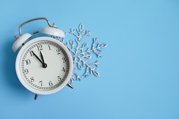 New Year white alarm clock. Blue bright background. Concept of celebrating the new year, christmas.