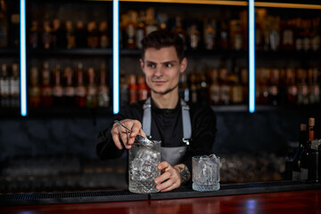 Professional male bartender makes an alcoholic cocktail