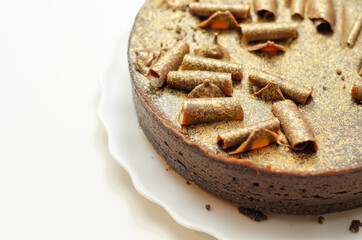 Digestive biscuit base with chocolate cheesecake and pockets of salted caramel sauce, topped with chocolate ganache, milk chocolate curls, and gold shimmer
