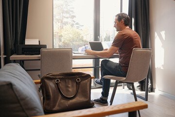 Serious aged man working online in office