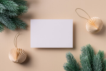 Greeting card mockup scene with blank paper card and christmas decorations. Flat lay for Merry Christmas or Happy New Year. beige background