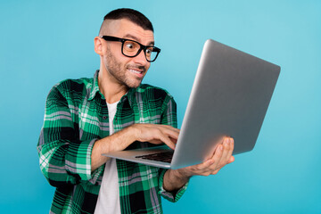 Photo portrait young man in glasses crazy browsing internet with computer isolated pastel blue color background